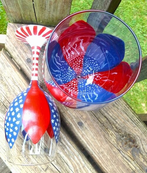 Check out these Fourth of July Crafts. You can make any celebration patriotic with these 4th of July Crafts for your home. Painted wine glass on outside table.