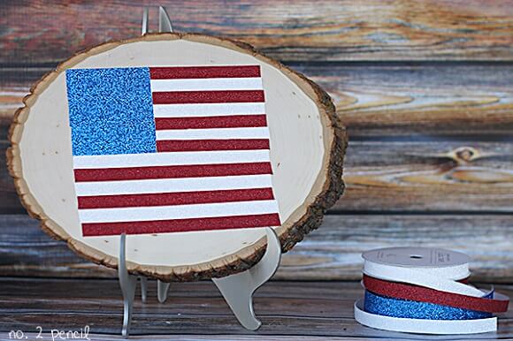 Check out these Fourth of July Crafts. You can make any celebration patriotic with these 4th of July Crafts for your home. Glitter tape flag on wood.