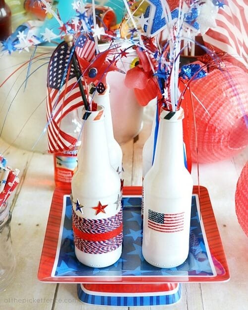 Check out these Fourth of July Crafts. You can make any celebration patriotic with these 4th of July Crafts for your home. Bottle centerpiece on table.