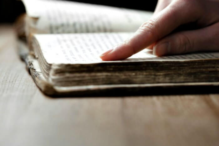 Find Bible Verses here to encourage you. 10 Bible verses to memorize when you are discouraged and need some encouragement. Hand looking up a Bible verse.