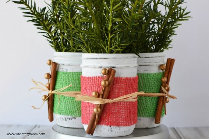 If you're looking for holiday centerpiece ideas,make this rustic Christmas centerpiece.This mason jar Christmas centerpiece is so simple and easy! Mason jars grouped together with greenery.