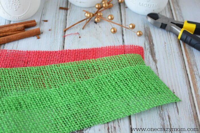 If you're looking for holiday centerpiece ideas,make this rustic Christmas centerpiece.This mason jar Christmas centerpiece is so simple and easy! Red and Green burlap ribbon.