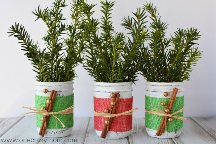If you're looking for holiday centerpiece ideas,make this rustic Christmas centerpiece.This mason jar Christmas centerpiece is so simple and easy! Mason jars grouped together with greenery.