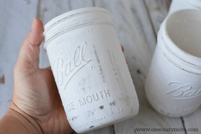 If you're looking for holiday centerpiece ideas,make this rustic Christmas centerpiece.This mason jar Christmas centerpiece is so simple and easy! Mason jar painted white.