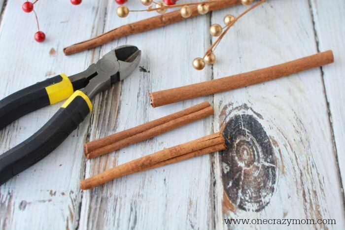 If you're looking for holiday centerpiece ideas,make this rustic Christmas centerpiece.This mason jar Christmas centerpiece is so simple and easy! Cinnamon sticks being trimmed.