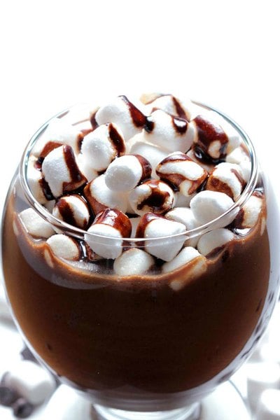Try these easy hot chocolate recipes for an amazing treat everyone will love this Winter. 20 of the best hot cocoa recipes. You will love these homemade hot chocolate recipes that are made in the crock pot, some with cocoa powder. Learn how to make your own hot chocolate at home! #eatingonadime #hotchocolaterecipes #drinkrecipes #winterrecipes Hot chocolate in a clear glass with marshmallows.
