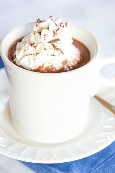Try these easy hot chocolate recipes for an amazing treat everyone will love this Winter. 20 of the best hot cocoa recipes. You will love these homemade hot chocolate recipes that are made in the crock pot, some with cocoa powder. Learn how to make your own hot chocolate at home! #eatingonadime #hotchocolaterecipes #drinkrecipes #winterrecipes Italian hot chocolate in a white cup topped with whipped cream.