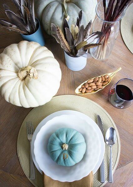 Make your table beautiful with these easy Thanksgiving table decor ideas. 20 Thanksgiving table decorating ideas that are budget friendly and easy to make. Feather centerpiece in between pumpkins.
