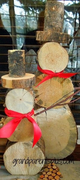 Get your home ready for Christmas with these 25 Christmas Porch Decorating Ideas. Beautiful Christmas porch ideas that are simple and budget friendly! Wooden snowmen with a bow.