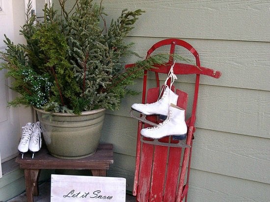 Get your home ready for Christmas with these 25 Christmas Porch Decorating Ideas. Beautiful Christmas porch ideas that are simple and budget friendly! Sled on front porch with ice skates.