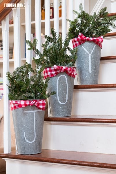 Get your home ready for Christmas with these 25 Christmas Porch Decorating Ideas. Beautiful Christmas porch ideas that are simple and budget friendly! Joy buckets on staircase.