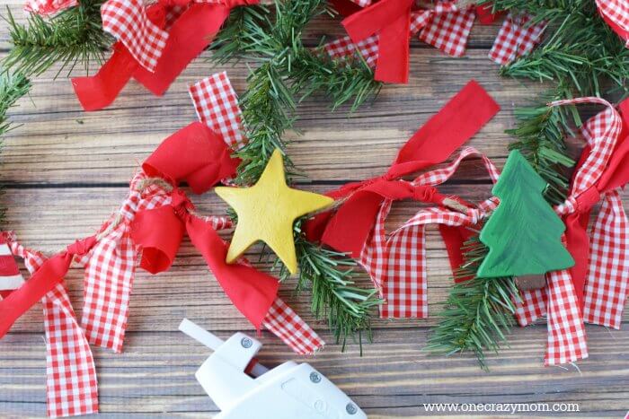 Garland makes your home festive for Christmas. DIY Christmas garland is perfect for the mantle or anywhere you need a festive touch. It's so easy to make! Garland with ornaments and ribbon.