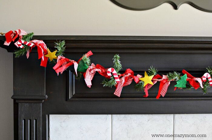 Garland makes your home festive for Christmas. DIY Christmas garland is perfect for the mantle or anywhere you need a festive touch. It's so easy to make! DIY Christmas Garland hanging on mantle.
