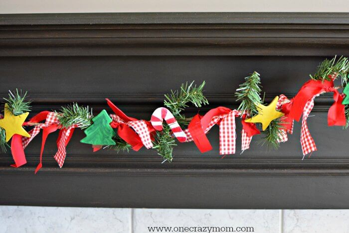 Garland makes your home festive for Christmas. DIY Christmas garland is perfect for the mantle or anywhere you need a festive touch. It's so easy to make! DIY Christmas Garland hanging on mantle.