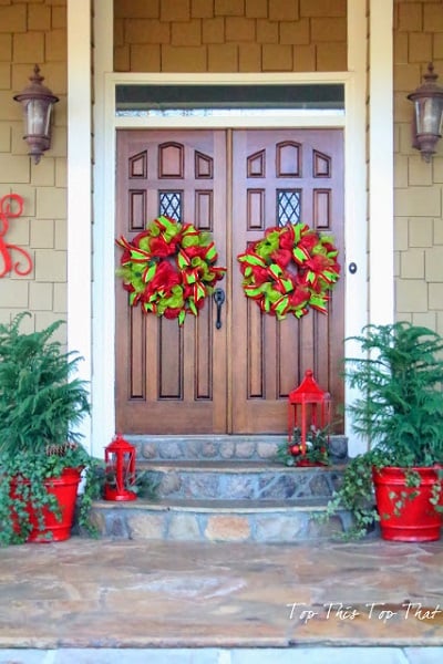 Get your home ready for Christmas with these 25 Christmas Porch Decorating Ideas. Beautiful Christmas porch ideas that are simple and budget friendly! Wreath on double doors.