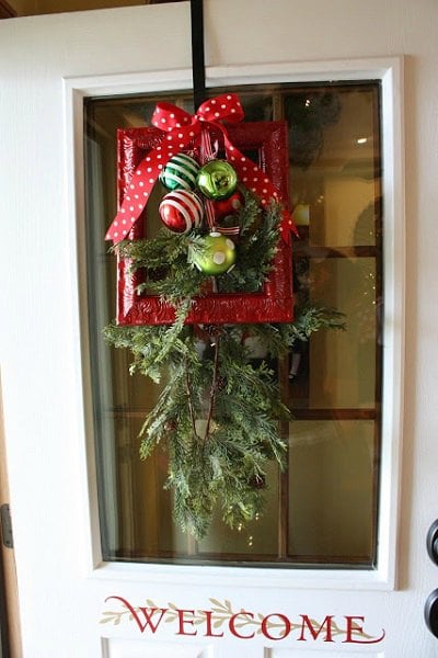 Get your home ready for Christmas with these 25 Christmas Porch Decorating Ideas. Beautiful Christmas porch ideas that are simple and budget friendly! Picture frame wreath with greenery.