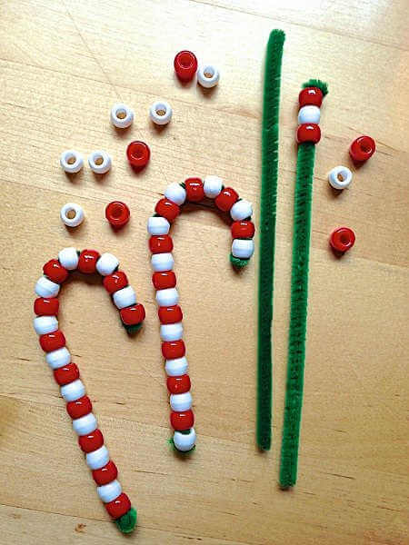 Find Easy Christmas Crafts for kids that are easy to do. They will love these Christmas crafts for kids. 20 Christmas craft ideas for kids that are frugal and great for gifts or ornaments. These fun projects are great for toddlers and older kids too. Perfect for school or for Christmas decorations! #onecrazymom #christmascrafts #kidcrafts Candy cane made out of beads.