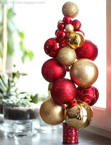 Create Christmas table top decorations with these easy ideas. 15 DIY Christmas table decorations anyone can make. Simple Christmas table decoration ideas. Ornament tree made out of red and gold ornaments.