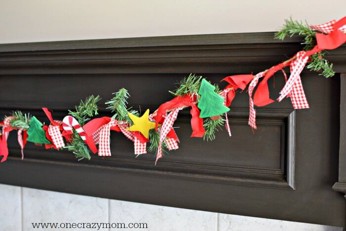 Garland makes your home festive for Christmas. DIY Christmas garland is perfect for the mantle or anywhere you need a festive touch. It's so easy to make! DIY Christmas Garland hanging on mantle.