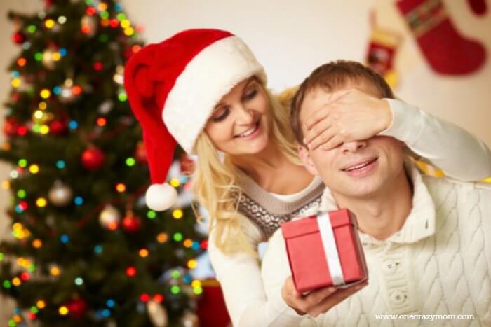 Find the best Electronic Gifts for Men. 20 gift ideas for men. Tech Gifts for men that won't break the bank.Gadgets for men they will love for Christmas. Man and women in front of Christmas tree.