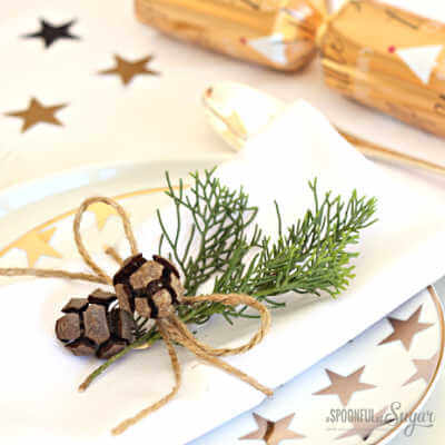 Create Christmas table top decorations with these easy ideas. 15 DIY Christmas table decorations anyone can make. Simple Christmas table decoration ideas. Napkin holders made out of twine and greenery.