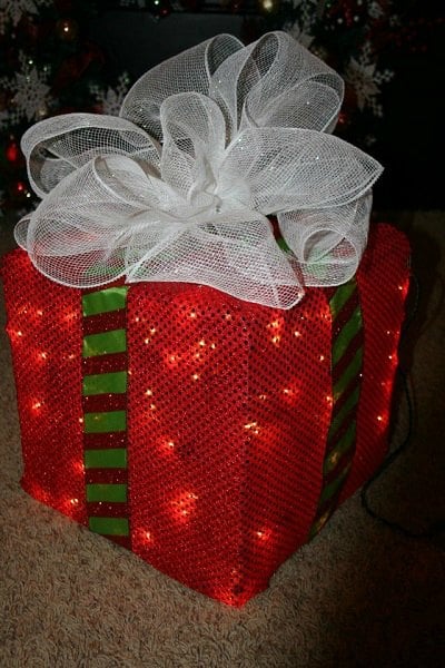 Get your home ready for Christmas with these 25 Christmas Porch Decorating Ideas. Beautiful Christmas porch ideas that are simple and budget friendly! Gift box with lights on porch.