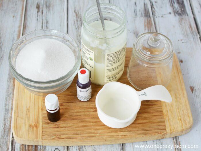 Make this easy Peppermint Sugar Scrub! Homemade Peppermint Sugar Scrub Recipe is moisturizing & smells amazing. Perfect for gifts! Ingredients for peppermint sugar scrub - coconut oil, white sugar, peppermint essential oil, red food coloring.