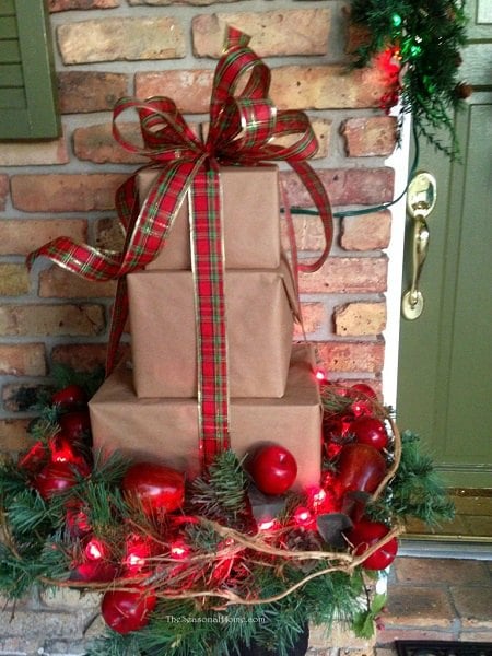 Get your home ready for Christmas with these 25 Christmas Porch Decorating Ideas. Beautiful Christmas porch ideas that are simple and budget friendly! Wrapped Christmas gifts with greenery.
