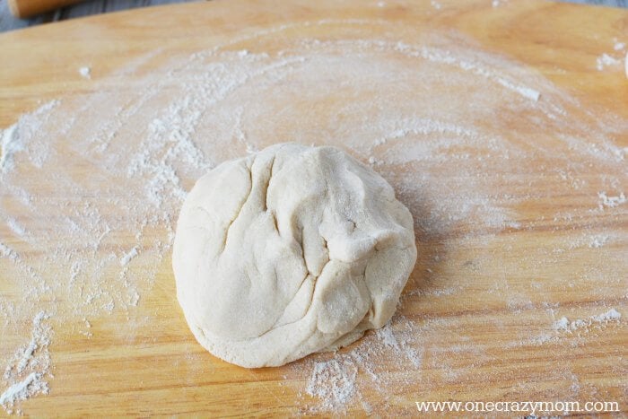 Make special memories with this simple and fun Salt Dough Ornament Recipe for Christmas. Learn how to make salt dough ornaments so easy the entire family can help! This great ornament DIY is perfect for kids. #onecrazymom #christmasornaments #DIYornaments #saltdoughornaments Dough in a ball.