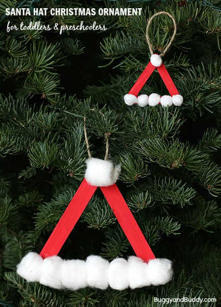 Find Easy Christmas Crafts for kids that are easy to do. They will love these Christmas crafts for kids. 20 Christmas craft ideas for kids that are frugal and great for gifts or ornaments. These fun projects are great for toddlers and older kids too. Perfect for school or for Christmas decorations! #onecrazymom #christmascrafts #kidcrafts Santa hat ornament on tree.