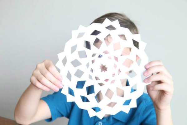 Find Easy Christmas ideas for families here. 20 Fun Christmas activities ideas for kids or toddlers from crafts to games that kids will love. Christmas activities to keep them busy. These are perfect for the classroom too! #onecrazymom #christmasactivities #kidactivities Child holding paper snowflake.
