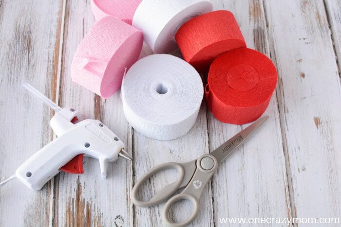 Make this festive heart shaped wreath for Valentine's Day. Learn how to make a heart wreath. This Valentine wreath is so simple and easy to make. Supplies needed for wreath - crepe paper, cardboard, paper, scissors, pen, ruler, glue.