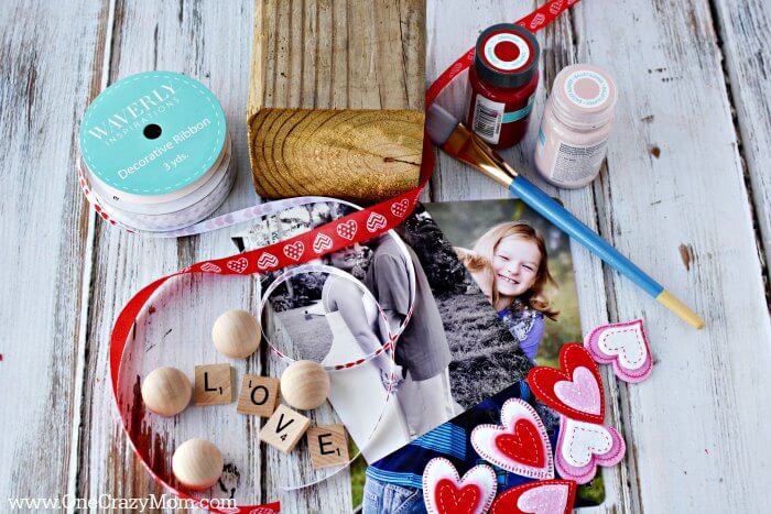 Make this adorable Wooden Photo Block sure to be the perfect gift. You will love how this DIY Photo Block turns out. Make this personalized photo block with just a few supplies. Supplies needed for DIY Photo Block - wodoen blocks, paint, ball knobs, glue, ribbon, heart shapes, paint brush.