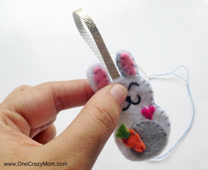 Easter felt crafts are so fun! Learn how to make a Bunny Charm. DIY Easter crafts are so simple. Kids will love this easy bunny craft! Find Easter craft ideas for kids. Easter crafts for kids they will love! Bunny with stuffing being sewn in.