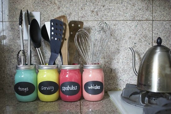 You will love these Dollar Store Kitchen Organization ideas! 20 Kitchen Organization hacks to get your kitchen in order for just a $1! You can't beat that! Mason jars painted and holding utensils.