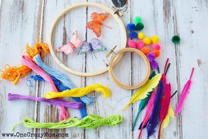 The kids will have a blast learning how to make a dream catcher. Get creative and make a fun and whimsical diy dream catcher today. Embroidery Hoops, thread, pom poms, feathers and butterflys