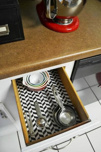 You will love these Dollar Store Kitchen Organization ideas! 20 Kitchen Organization hacks to get your kitchen in order for just a $1! You can't beat that! Wrapped paper in draws as liner.