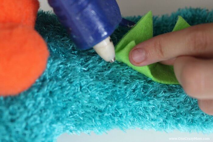 Learn how to make a hand puppet! It's very simple to make this diy sock puppet. Kids will love this easy diy hand puppet. Once you know how to make a sock puppet, it's so much fun! Make different puppets and have a puppet show! Green felt being glued to the back.