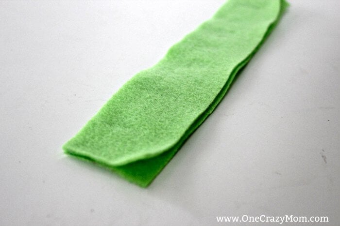 Learn how to make a hand puppet! It's very simple to make this diy sock puppet. Kids will love this easy diy hand puppet. Once you know how to make a sock puppet, it's so much fun! Make different puppets and have a puppet show! Green felt folded.