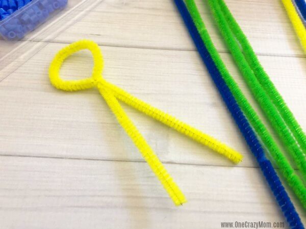 Learn how to make a bubble wand. Make this diy bubble wand for tons of fun. Homemade bubble wands are easy to make. Kids will love decorating the wands with beads. Pipe cleaners being twisted.