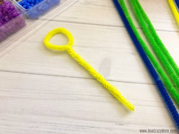 Learn how to make a bubble wand. Make this diy bubble wand for tons of fun. Homemade bubble wands are easy to make. Kids will love decorating the wands with beads. Pipe cleaner twisted into shape.