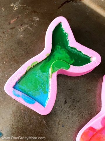 Learn how to make crayons shaped like mermaid tails! These are perfect for a mermaid birthday party. It's so easy once you know how to make crayons. Try these fun mermaid tails crayons. Kid's will love all the glitter! They are so pretty! Melted crayons in mold.