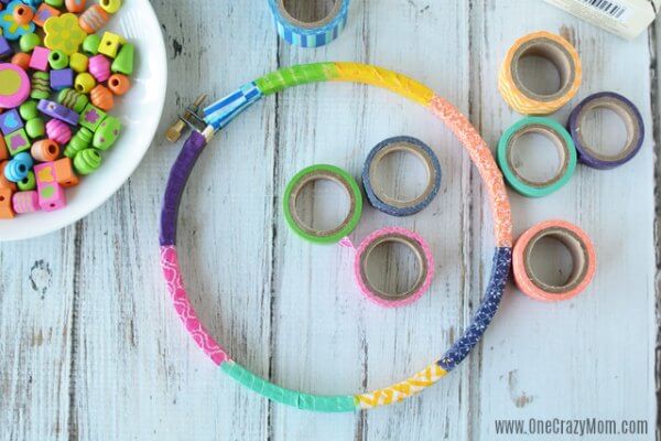 DIY wind chimes are really simple to make. Learn how to make wind chimes. It's so simple and easy. Everyone will have a blast making these pretty wind chimes. Hoop with washi tape wrapped around.