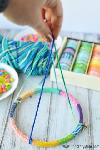 DIY wind chimes are really simple to make. Learn how to make wind chimes. It's so simple and easy. Everyone will have a blast making these pretty wind chimes. String being attached to hoop.