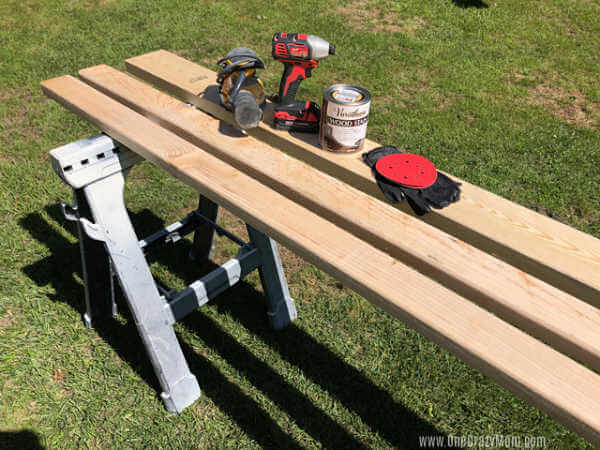 Learn how to make a DIY Blanket Ladder for a fraction of the cost of store bought. This blanket ladder DIY is super easy and so pretty. Pine boards on a sawhorse.
