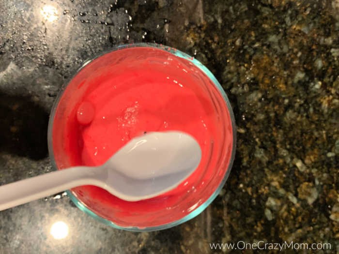 Spoon mixing pigment color into mixture.