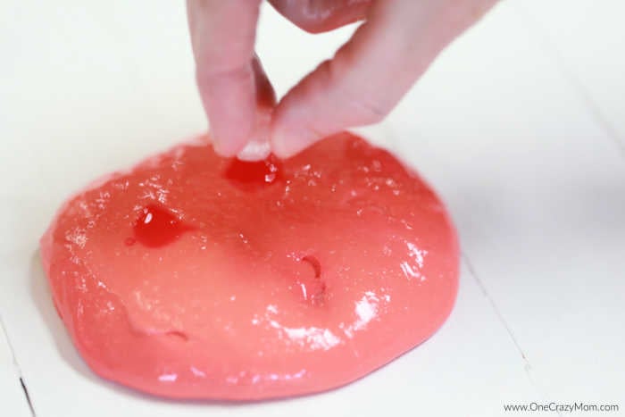 Learn how to make color changing slime and impress your kids. If they are crazy over slime, they are going to love making this color changing slime recipe. Hand playing with slime and ice.