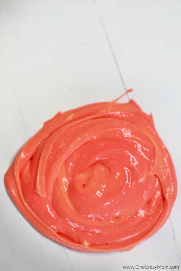 Learn how to make color changing slime and impress your kids. If they are crazy over slime, they are going to love making this color changing slime recipe. Swirl of slime on table.