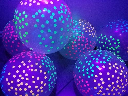 Find over 20 Glow in the dark party ideas that are easy and budget friendly. Your next party will be fabulous with these glow in the dark party decorations. Fluorescent balloons in a pile.