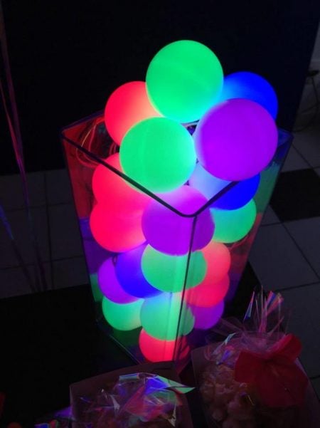 Find over 20 Glow in the dark party ideas that are easy and budget friendly. Your next party will be fabulous with these glow in the dark party decorations. Glow in the dark centerpiece with balls.